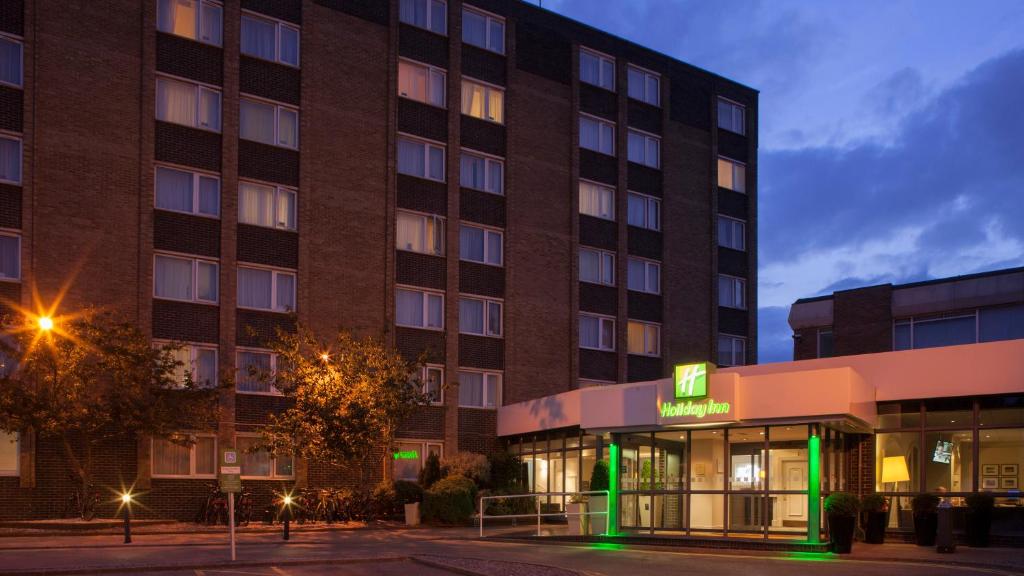 朴次茅斯假日朴茨茅斯酒店的酒店大楼前面有绿色标志