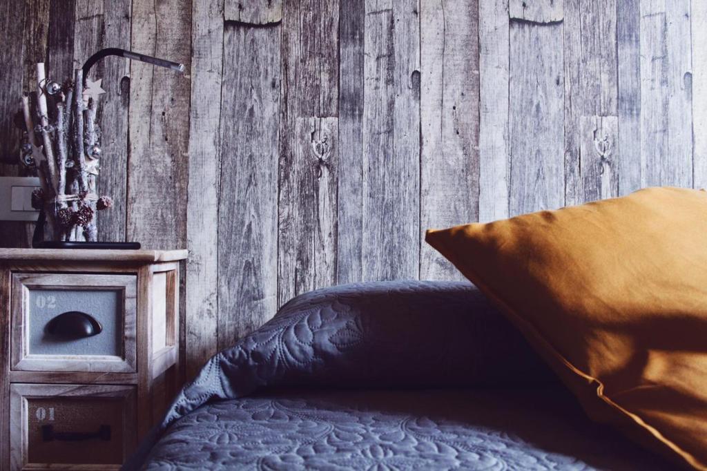 蒂沃利ApartHotel Le Sirene - CHALET的一间卧室设有一张床和木墙