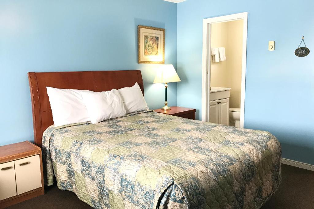 特伦顿Bayside Motel Trenton的一间卧室设有一张床和蓝色的墙壁