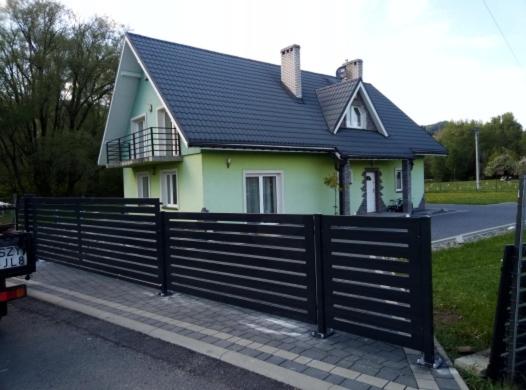 文盖尔斯卡－古尔卡Willa na Wczasowej的前面有黑色围栏的房子