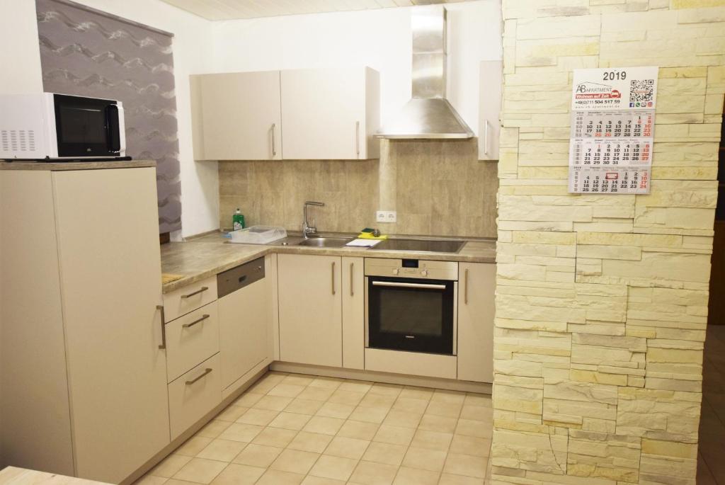 斯图加特Apartment Möhringen的厨房配有白色橱柜、水槽和冰箱。