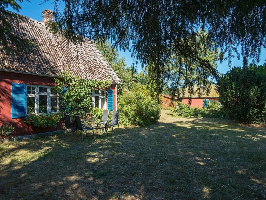 Hårup6 person holiday home in Br dstrup的前面有长凳的红色房子