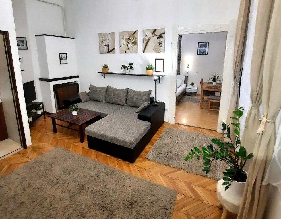 布达佩斯中央金子公寓的客厅配有沙发和桌子