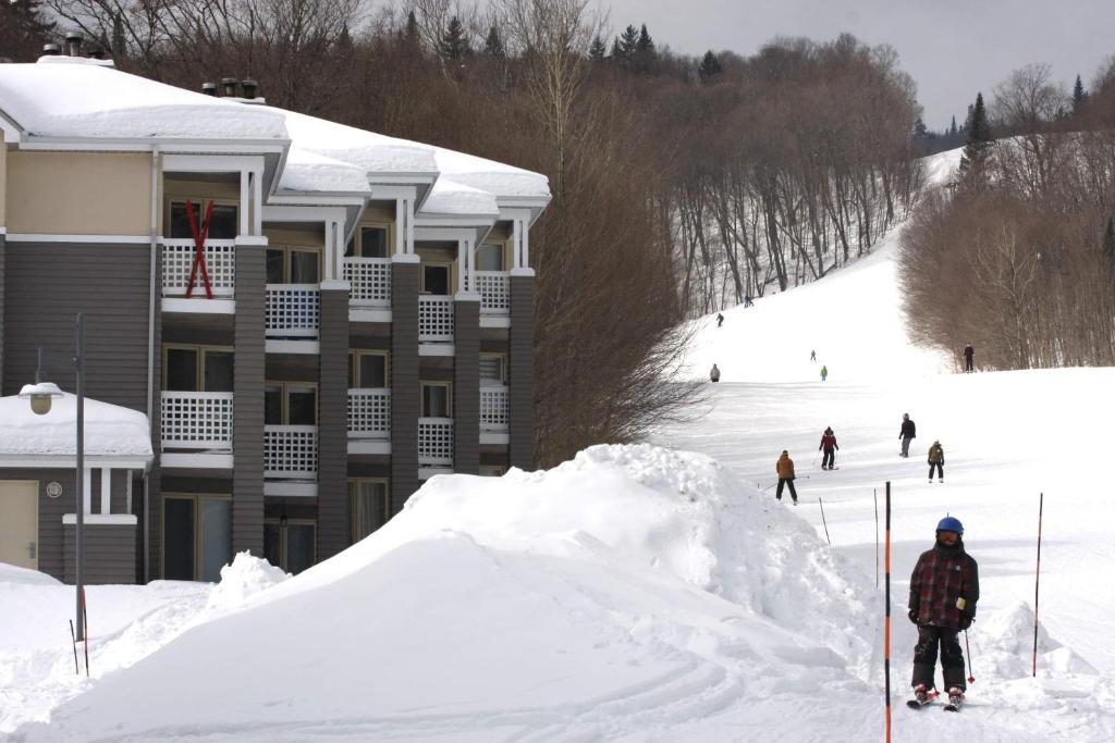 斯托纳姆Ski-in, ski-out chaleureux studio loft au pied des pistes de ski的一群人沿着雪覆盖的斜坡滑雪