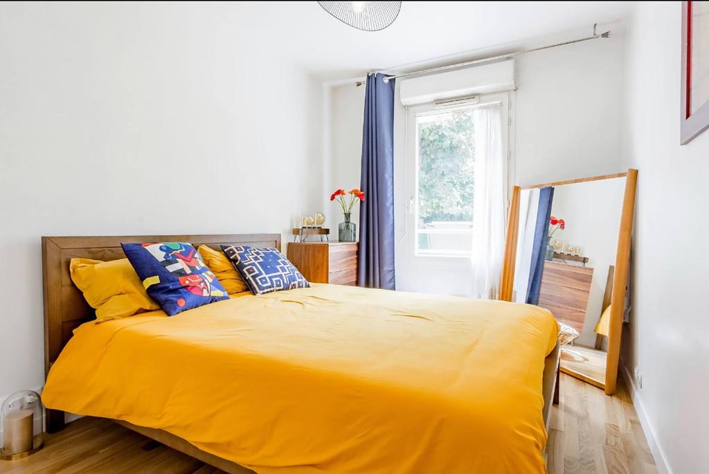 圣但尼Passion et détente by UTA HOUSE的一间卧室设有黄色的床和窗户。