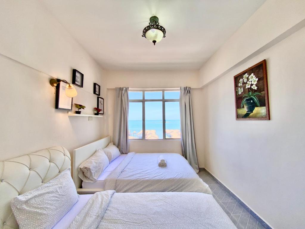 波德申Maison Seaview Suites Port Dickson的一间卧室设有一张床和一个窗口