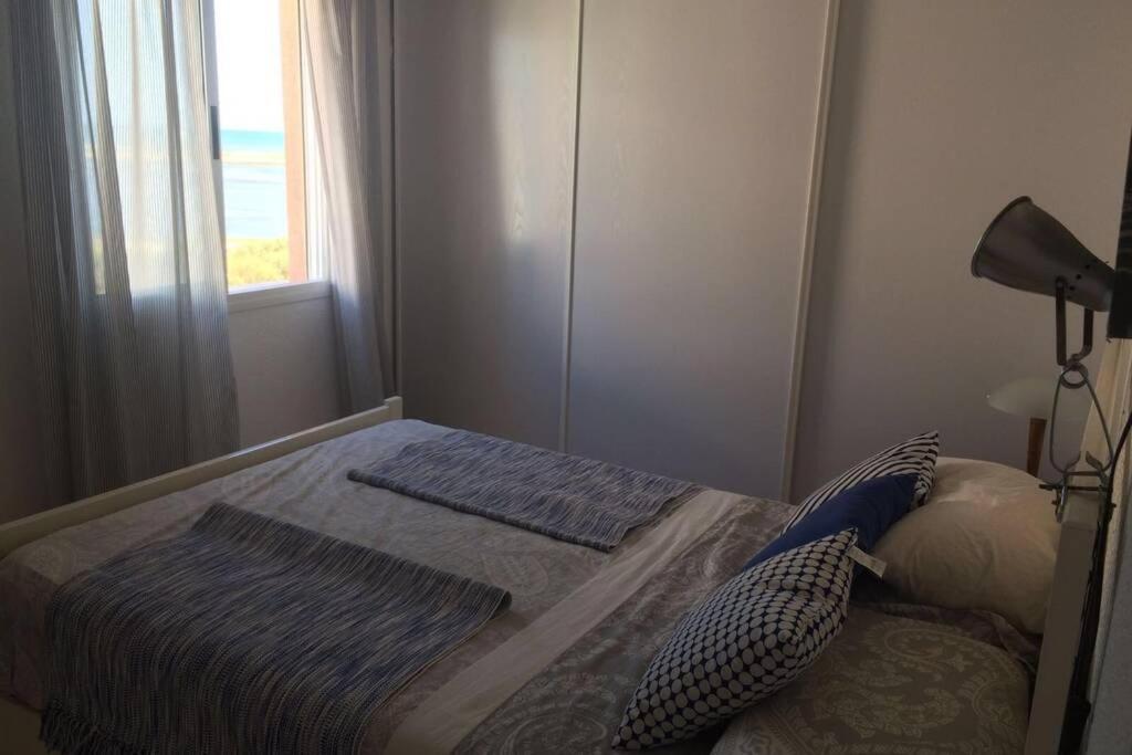 克莉丝蒂娜岛Delightful holiday in Isla Cristina. Seaside views的一间小卧室,配有一张带窗户的床