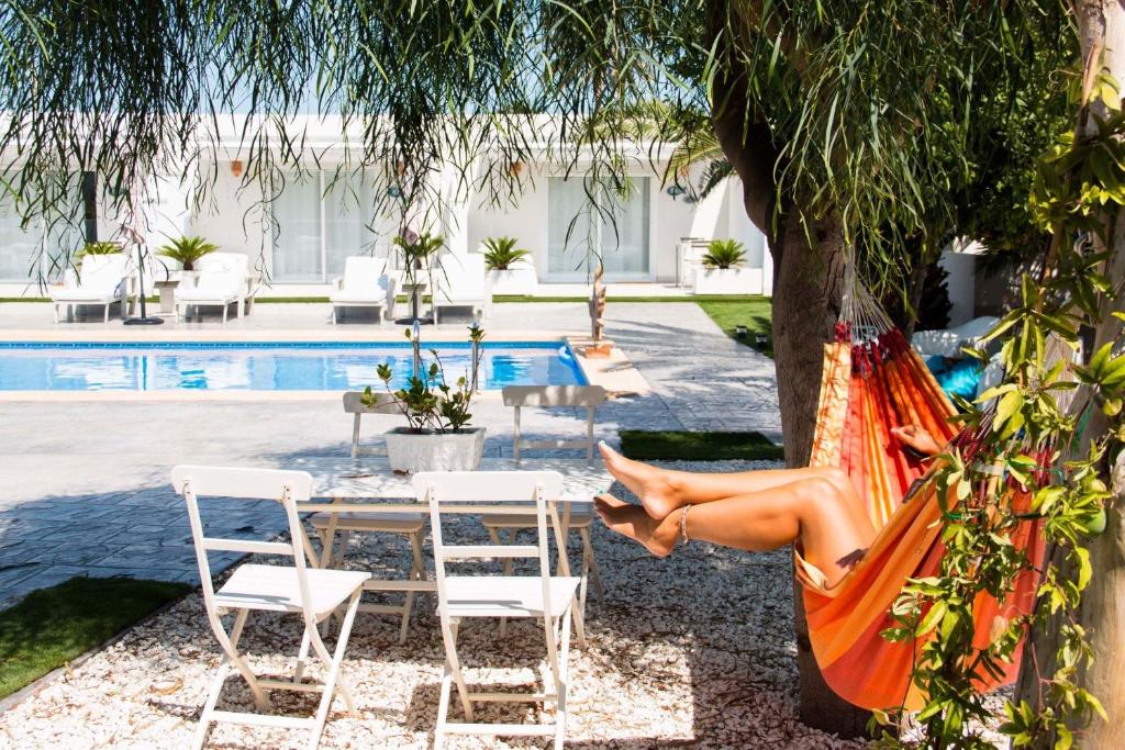埃尔切Finca Pura, Clothing Optional Guestrooms的坐在游泳池畔吊床上的女人