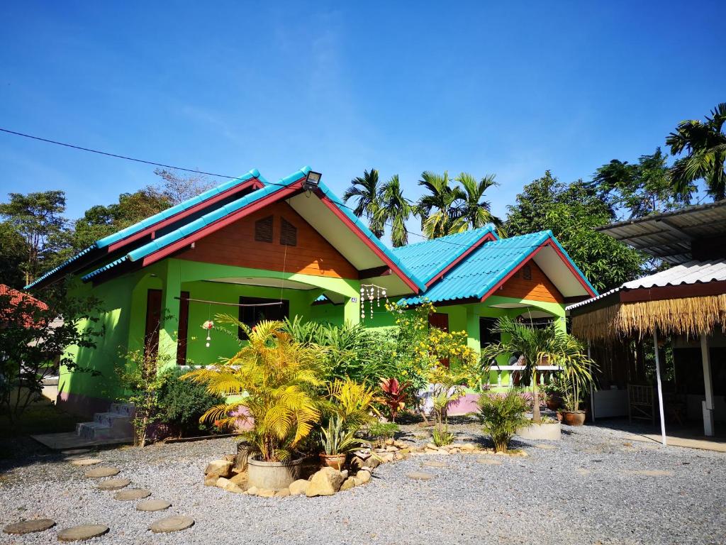 象岛Papaya Cottage Koh Chang的蓝色屋顶和一些植物的绿色房子