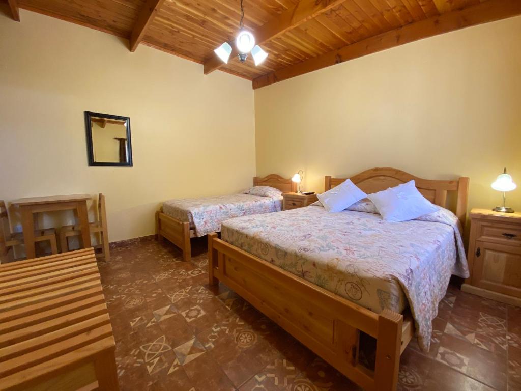 圣佩德罗·德·阿塔卡马Las Cornizas de Catarpe的一间卧室配有两张床、两张桌子和镜子