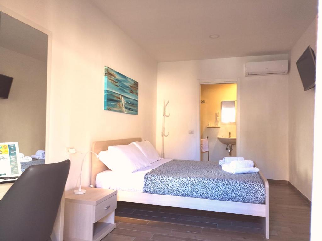 菲乌米奇诺阿克黛米酒店的一间卧室配有一张床和一张带台灯的书桌