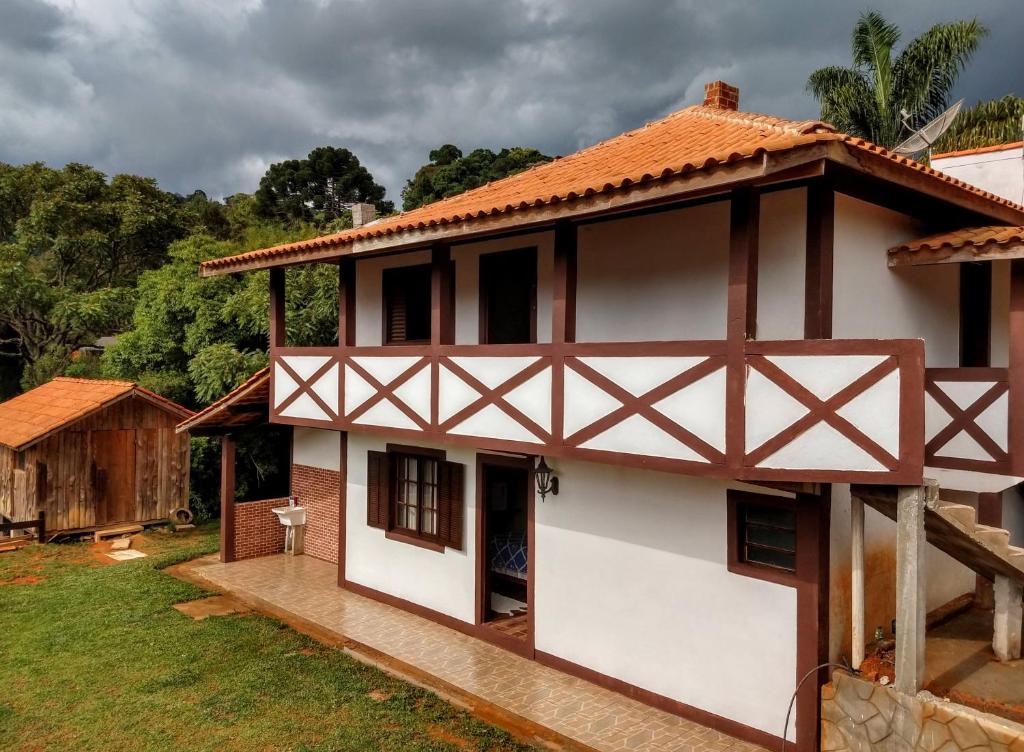 卡曼杜卡亚Pousada Caminho das Araucárias的白色房子,有红色屋顶
