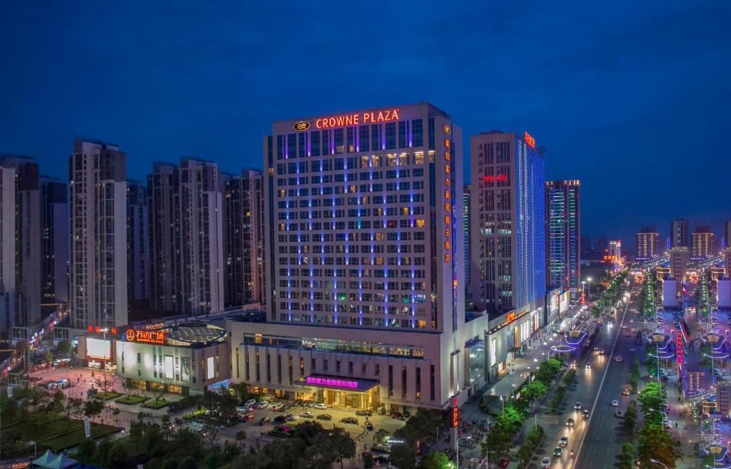 襄阳襄阳富力皇冠假日酒店 的一座大建筑,上面有夜间标志