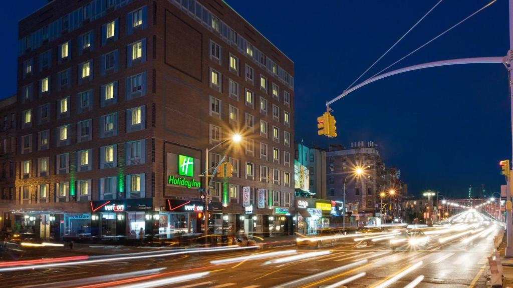 纽约下东城假日酒店的夜间有交通灯和建筑物的城市街道