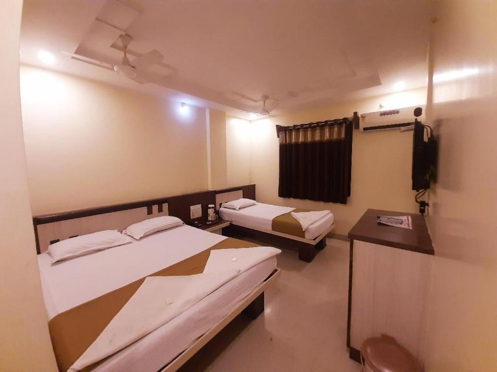 舍地Hotel Sai Balaji的小房间设有两张床和电视