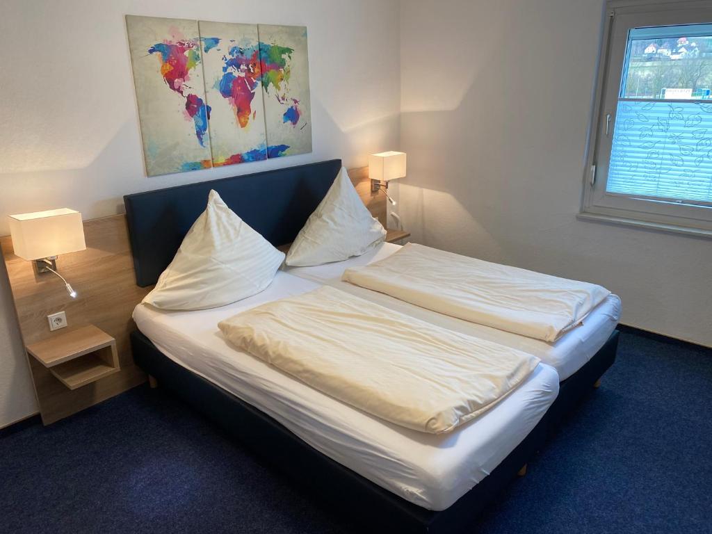 Knüllwald赫伯特汽车旅馆的一张位于房间的床,上面有两个枕头