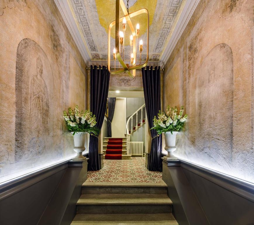 伊斯坦布尔The Soul Istanbul Hotel的走廊上设有吊灯和鲜花楼梯