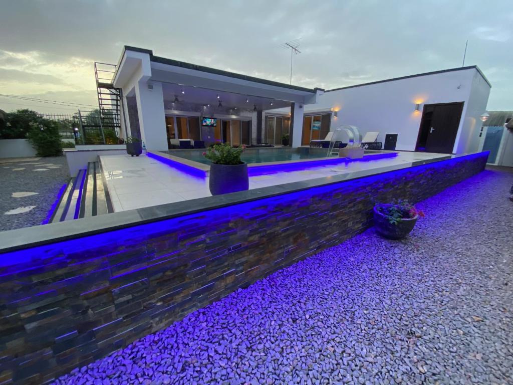 WanicaLiberdada Villa SURINAME的一座带紫色灯光游泳池的房子