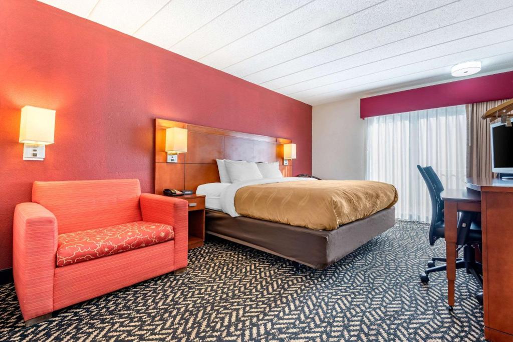 FalconerQuality Inn Falconer - Jamestown的酒店客房配有一张床、一张桌子和一把椅子。