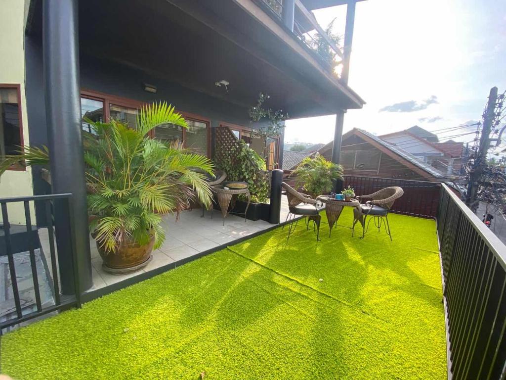 波普托Green​ house​ Samui的阳台铺有绿色地毯。