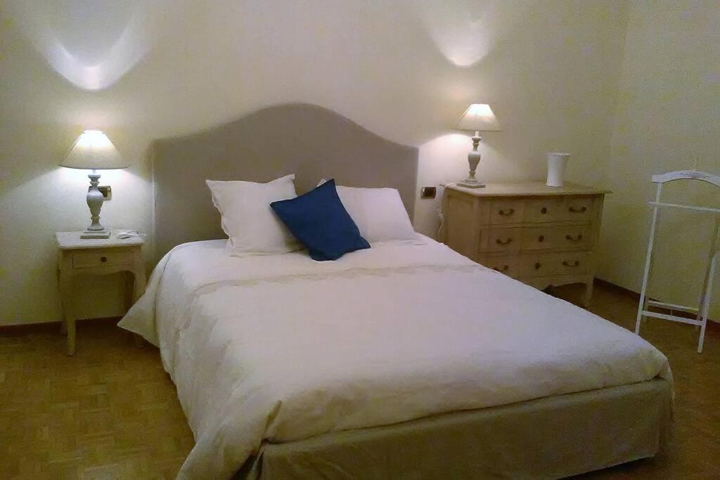 佛罗伦萨Charming Family Lodge With Private Garage的一间卧室配有一张带两盏灯的大型白色床。