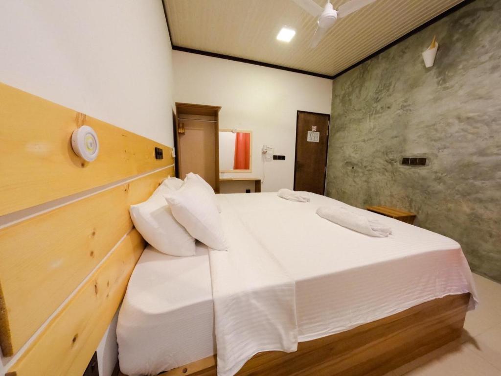 弗里德胡Huvan Inn的一间卧室配有一张带白色床单的大床