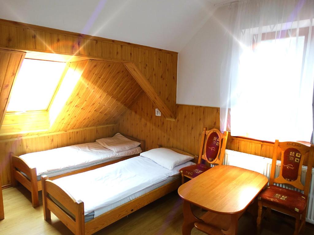 普热谢卡Ośrodek Wczasowy Zielona Gospoda的一间卧室设有两张床、一张桌子和一个窗口