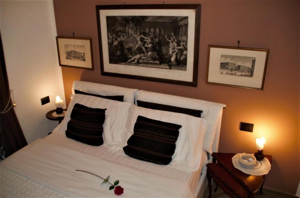 热那亚Ipazia House的卧室配有白色的床和黑白色枕头