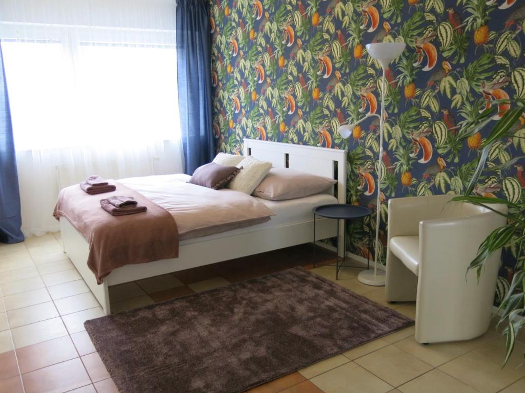 比尔森Apartmány Nad ZOO的一间卧室配有一张带花卉壁纸的床