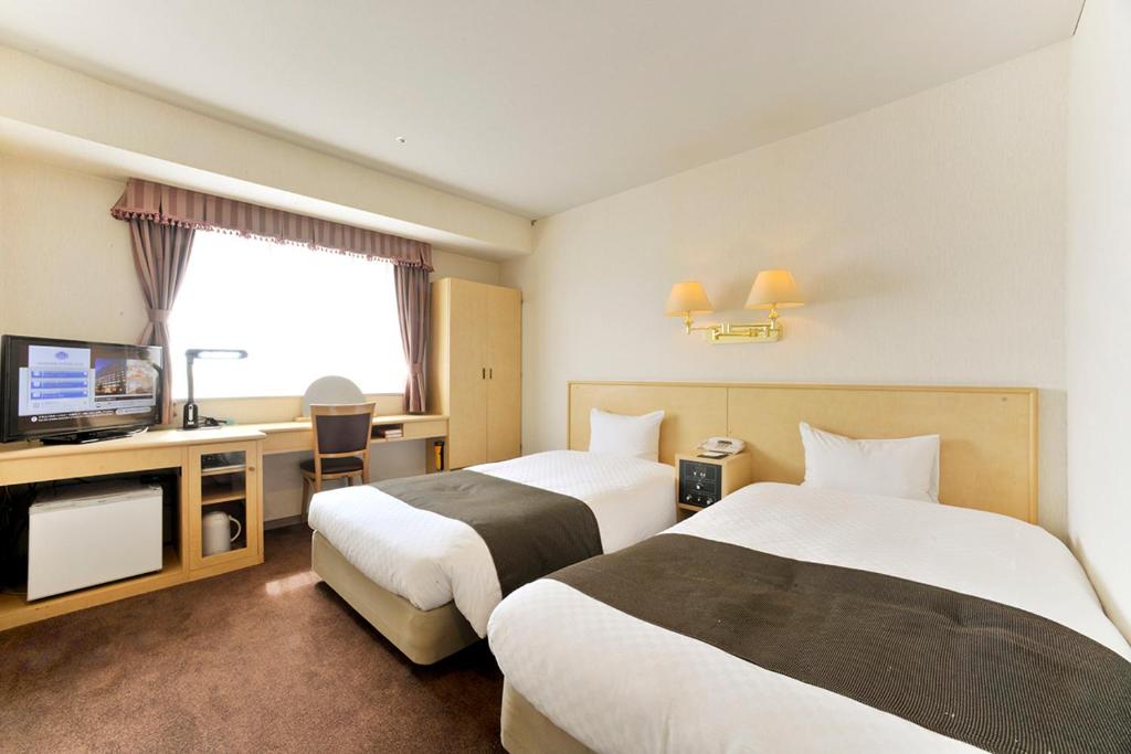 山形市山形会社酒店的酒店客房设有两张床和电视。
