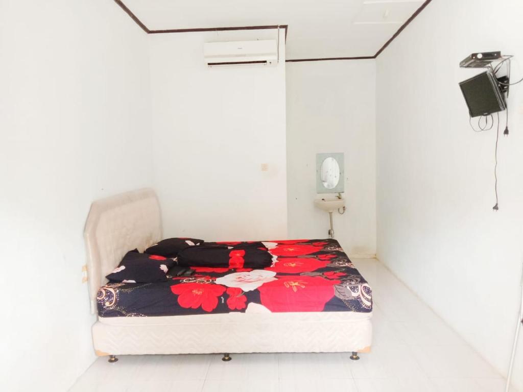 SawarnaOYO 3303 Penginapan Putri Asih Sawarna的白色客房的一张床位。