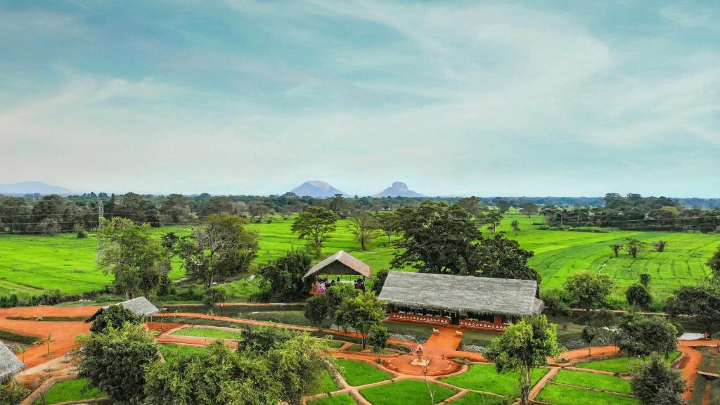 锡吉里亚Ayurvie Sigiriya - Ayurvedic Retreat by Thema Collection的享有以山为背景的农场的空中景致