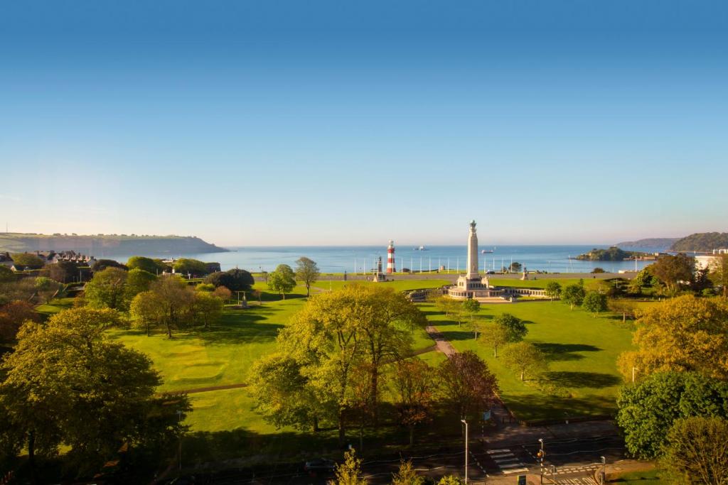 普里茅斯普里茅斯皇冠假日酒店的一座公园,有一座灯塔,有一座大海