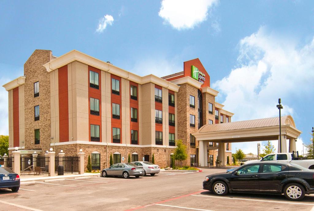 圣安东尼奥圣安东尼奥东南AT＆T中心智选假日套房酒店的停车场内有车辆的旅馆