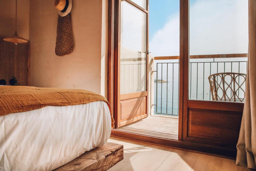 哈维亚Nomad Hotel - Xábia Port的一间卧室设有一张床和一个阳台