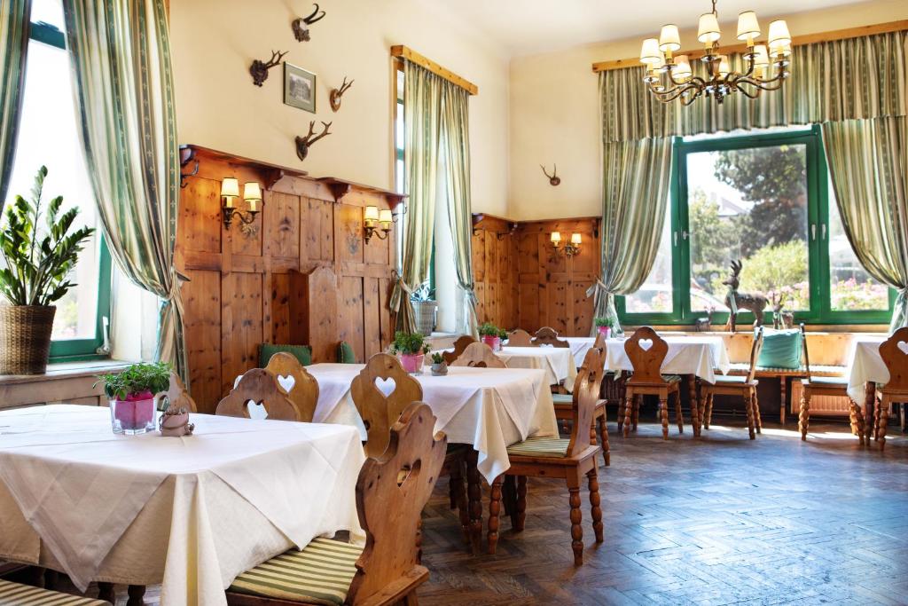 维也纳贝尔维特美泉宫酒店的餐厅设有白色的桌椅和窗户。