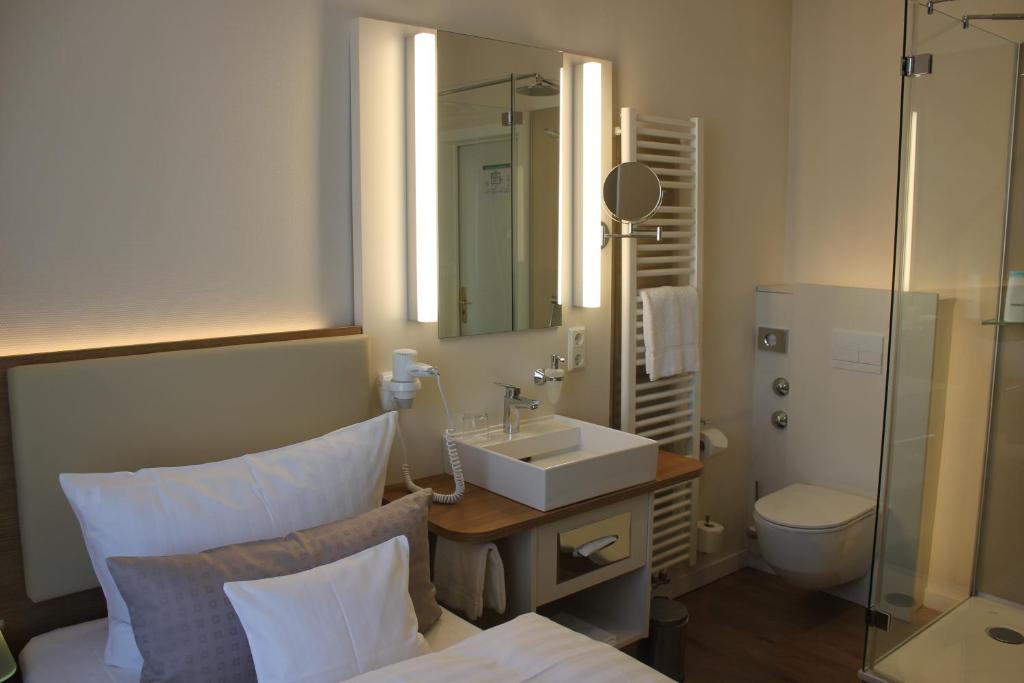 费尔贝特Stüttgens Hotel的一间带水槽、卫生间和镜子的浴室