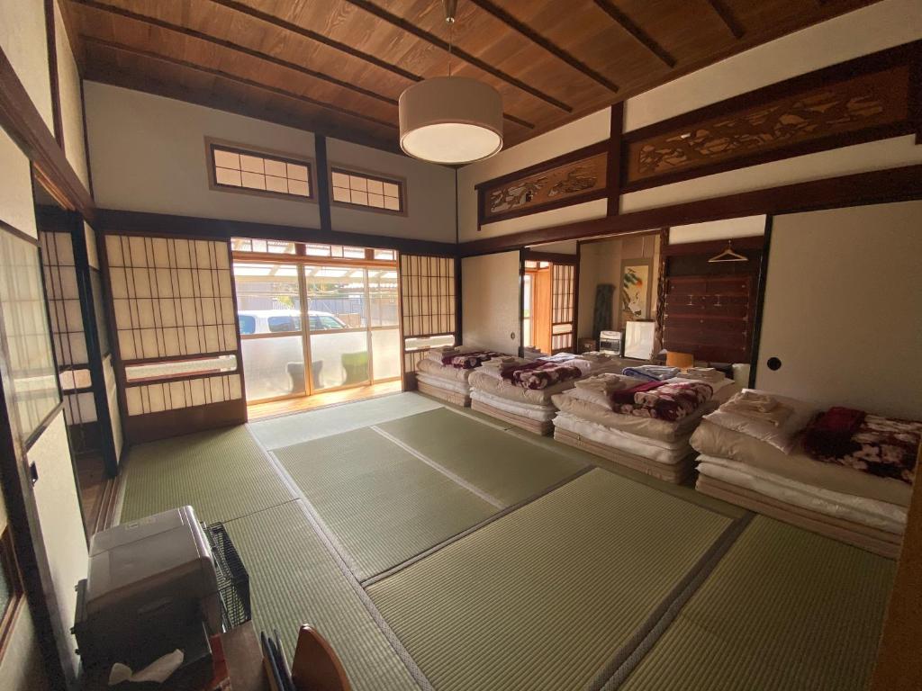 Shichigahama七滨町旅行者码头旅馆的带窗户的客房内设有几张床。