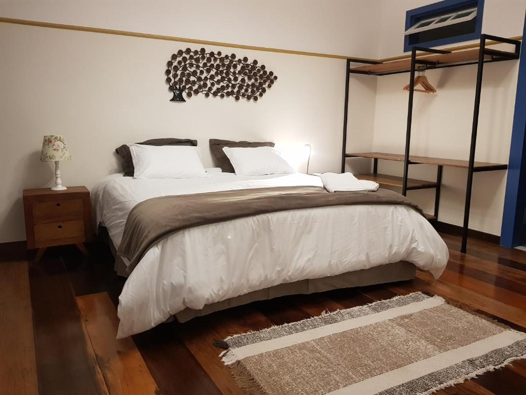 欧鲁普雷图Suite Família Inconfidentes的卧室配有带白色枕头的大床