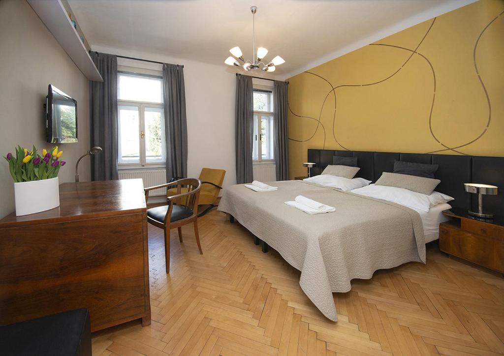 布尔诺Bed&Breakfast & Apartment Klafé的一间卧室配有一张床、一张书桌和一台电视