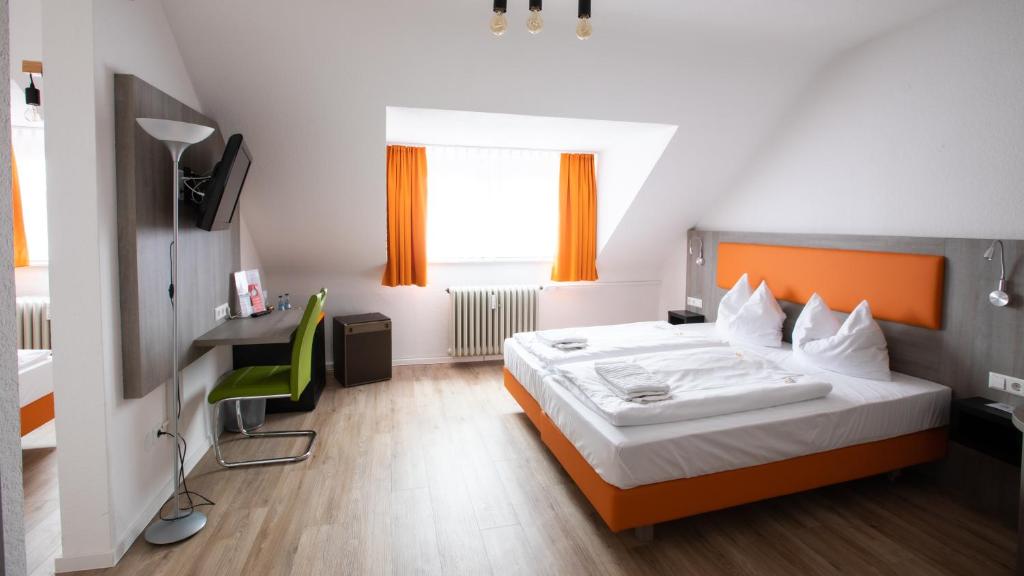 卡尔斯鲁厄阿斯托里亚酒店的一间卧室配有一张床和一张带绿椅的书桌