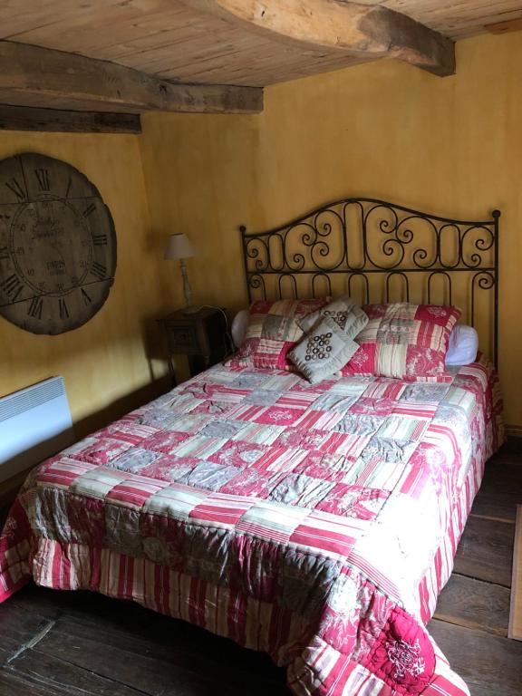AntraiguesLe Boustrophédon的卧室配有一张挂在墙上的带时钟的床
