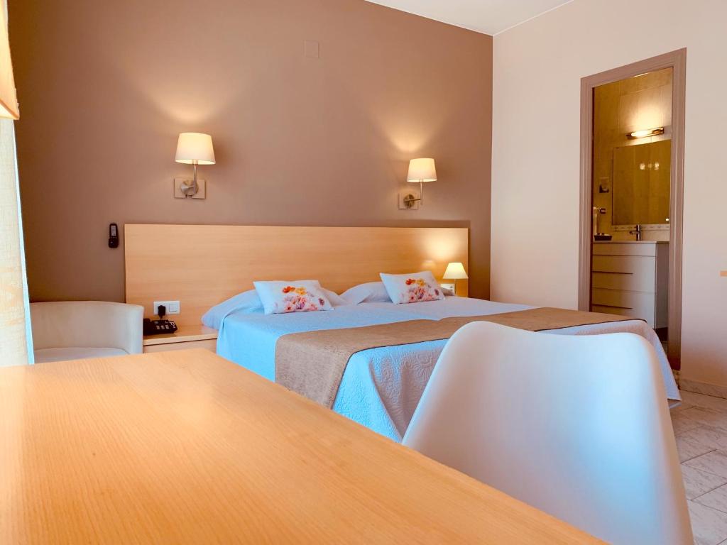 圣卡洛斯拉腊皮塔Hotel Restaurant Llansola的酒店客房设有两张床和一张桌子。