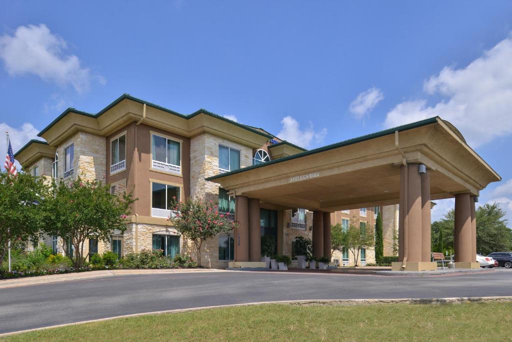 奥斯汀Holiday Inn Express & Suites Austin SW - Sunset Valley, and IHG Hotel的道路前有遮阳篷的建筑物