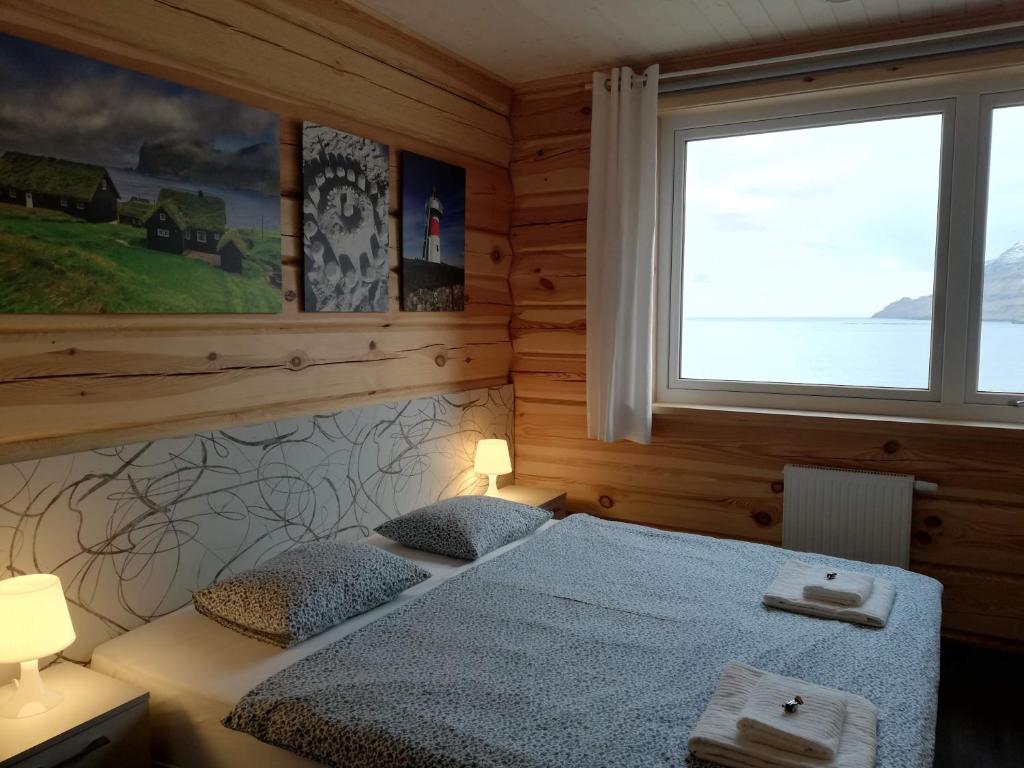 GøtugjógvGøtugjógv Log House的一间卧室设有两张床和窗户。