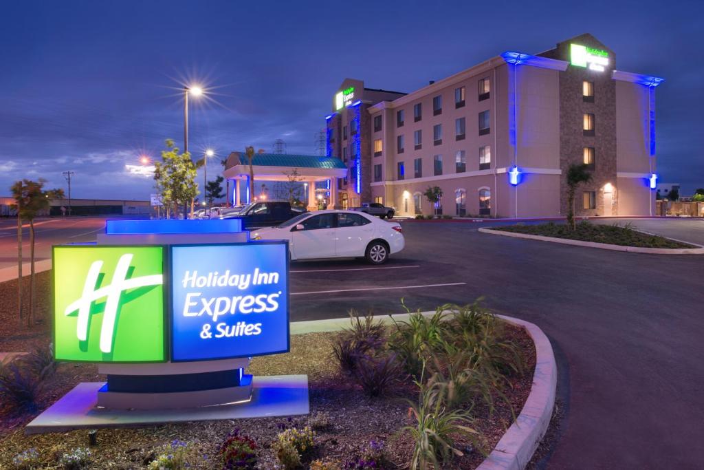贝克斯菲尔德Holiday Inn Express & Suites Bakersfield Airport, an IHG Hotel的酒店前停车场的标志