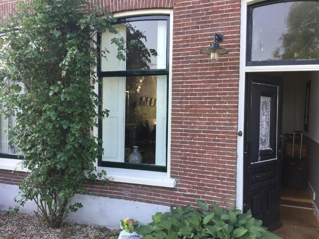 阿布考德Charming countryhouse near Amsterdam的红砖房子,有黑门和植物