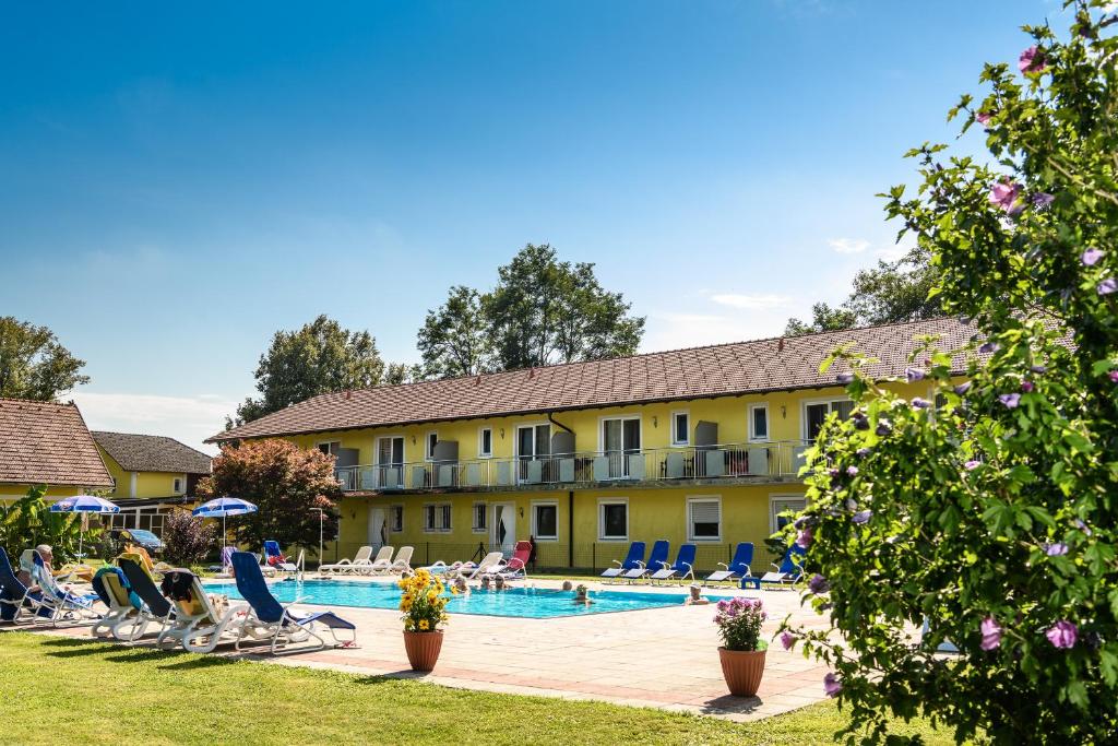 巴特拉德克斯堡Gasthof Zum Lindenhof的一座设有游泳池的酒店,人们坐在椅子上