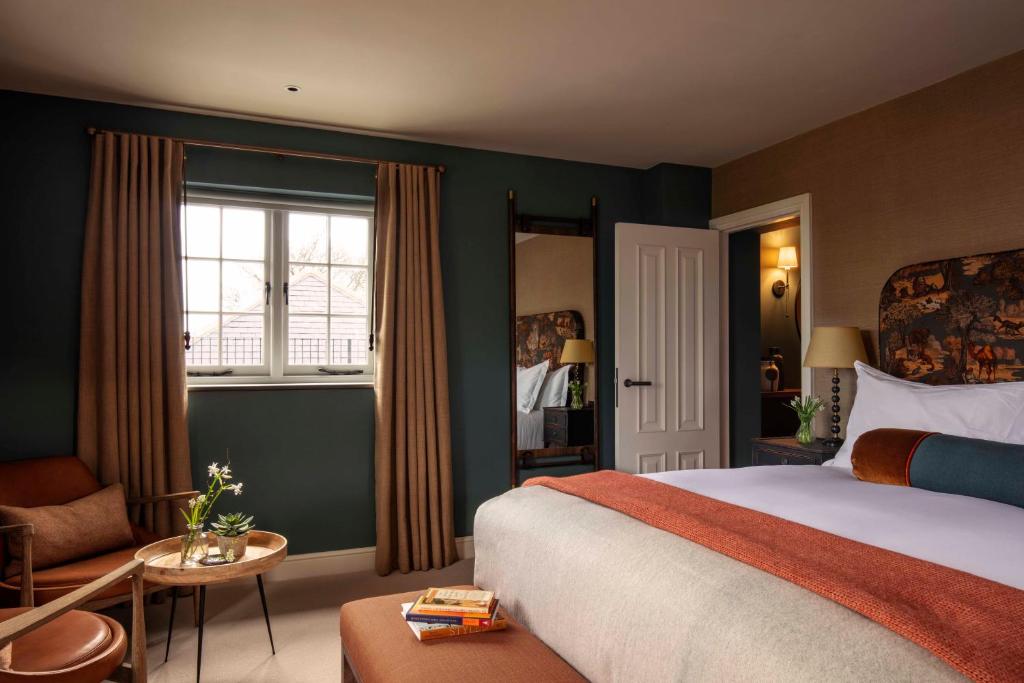 北安普敦The Falcon Hotel的卧室配有床、椅子和窗户。