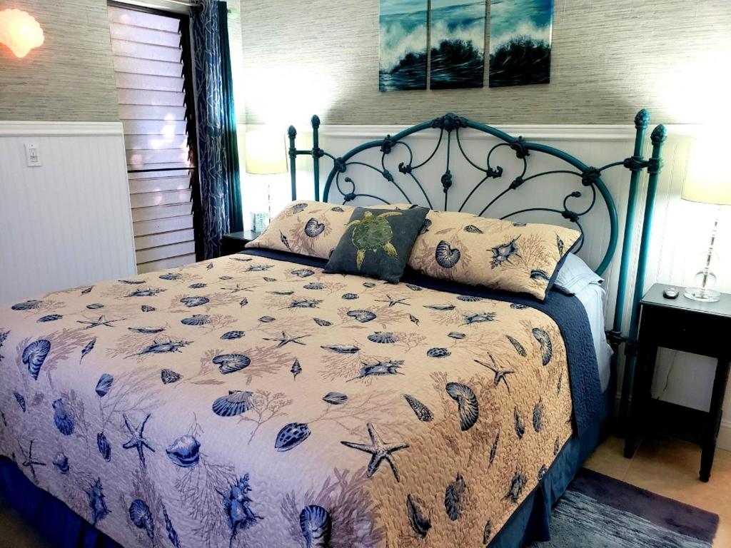 基黑毛伊岛宁静公寓的一间卧室配有一张带蓝色图案床罩的床。
